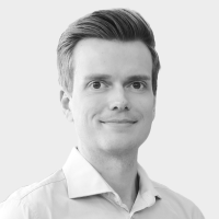Black and white portrait of Julian Senoner smiling in a collared shirt