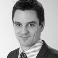 Black and white portrait of Peter Kaspar in a suit with striped shirt